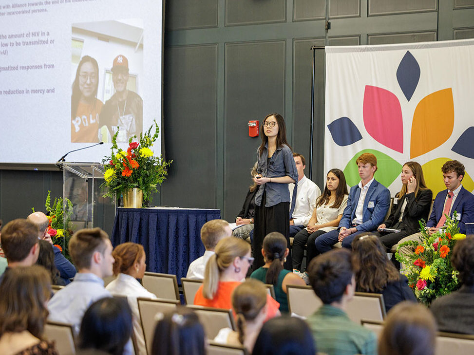Student on stage speaks to seated audience in McKenna Hall